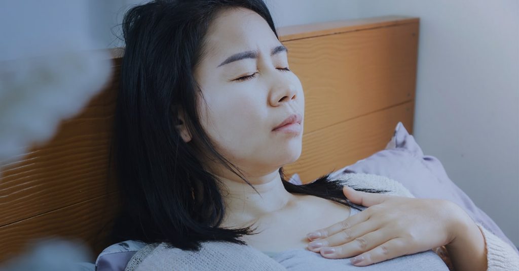 Woman trying to sleep with acid reflux